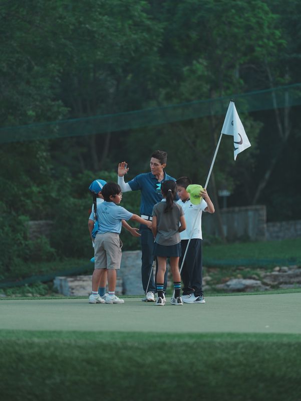 Golf coach high-fiving junior players at HKGTA